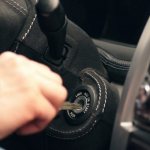 A man inserts the key into the ignition